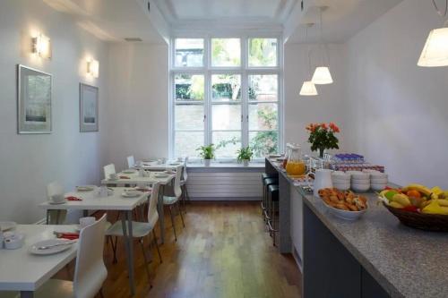 a dining room with tables and a large window at B&B Belgravia in London