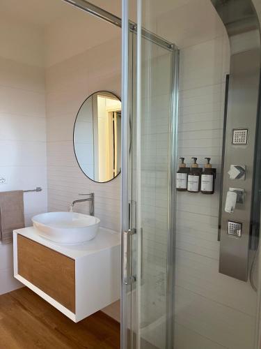 a bathroom with a sink and a glass shower at EOS Suite Apartment - a due passi da Piazza Pisanelli e Ospedale Panico in Tricase