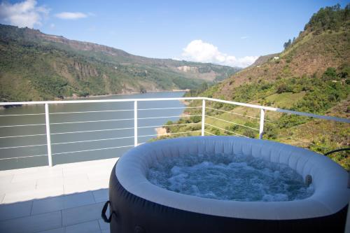 a hot tub on a balcony with a view of a river at Altavista Tinyhouse in Macanal