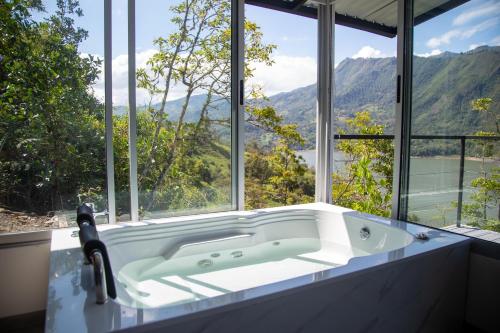 a bath tub in a bathroom with a large window at Altavista Tinyhouse in Macanal