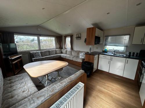 a living room with a couch and a table in a caravan at Buttercup Retreat 298 northfield in Skipsea