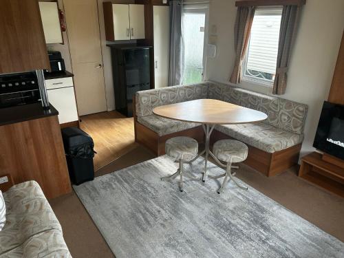 a living room with a table and a couch at Buttercup Retreat 298 northfield in Skipsea