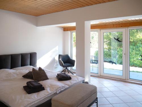 a bedroom with a bed and a chair and windows at Ferienhaus 76 in Freudenstadt