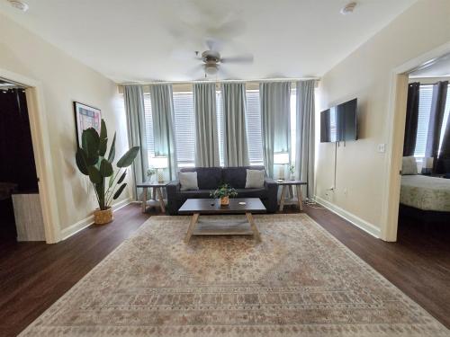 a living room with a couch and a table at Beautiful Walk to French Quarter, Pool, Gym, View in New Orleans