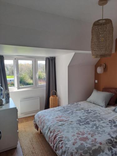a bedroom with a bed and two windows at La parenthèse de la Bouvaque in Abbeville