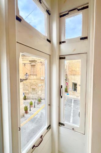 a window with a view of a street at Guesthouse Historical Palacinho de São Antonio in Birgu
