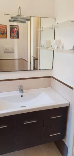a bathroom with a sink and a large mirror at Residenza Zuc in San Vito lo Capo