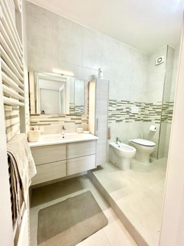 a white bathroom with a sink and a toilet at Mareline Seafront in Fano
