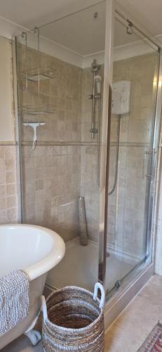 a bathroom with a shower and a tub and a sink at Rockleigh House in Corsham