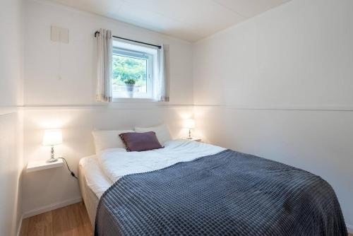 a bed in a white room with a window at Modern Fjord View Apt near City in Tromsø