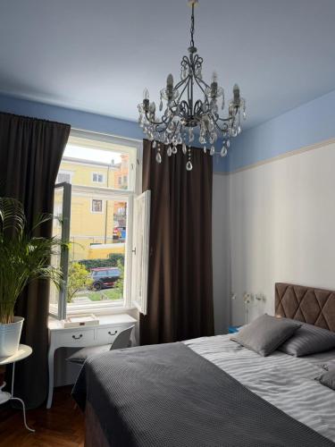 a bedroom with a bed and a window and a chandelier at Apartment with spacious terrace Villa Floramy in Opatija