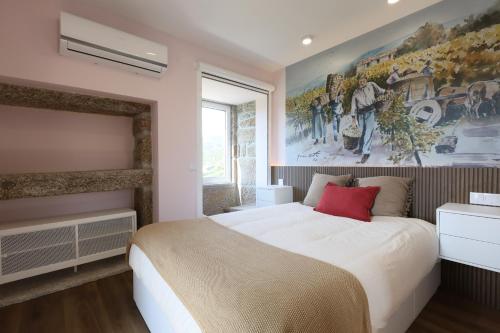 a bedroom with a large bed and a painting on the wall at Quinta do Giz in Baião
