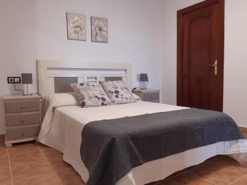 a bedroom with a bed and a nightstand with two lamps at Alojamiento Peña Dorada in Lumpiaque