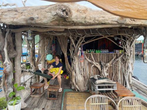 a woman and a child sitting in a tree house at Home Sake Hòn Sơn in Lai Sơn