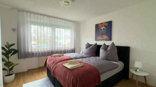 a bedroom with a large bed with a red blanket at Ferienwohnung City in Nollingen