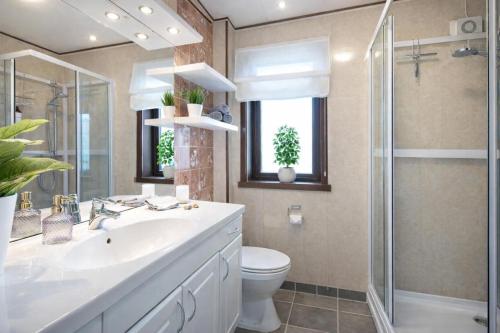 a bathroom with a toilet and a sink and a shower at Modern Fjord View Apt near City in Tromsø