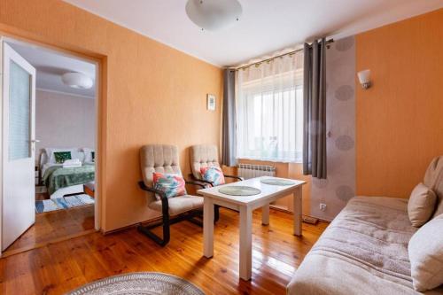 a living room with a couch and a table at Apartament pod mewą in Gdynia