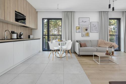 a living room with a couch and a table at Shellter Resort Apartment by Solarento in Rogowo