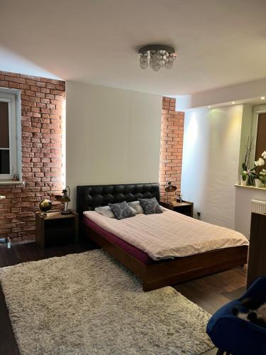 a bedroom with a bed and a brick wall at Ogrodowa Apartament in Ciechocinek