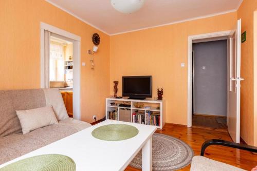 a living room with a couch and a tv at Apartament pod mewą in Gdynia