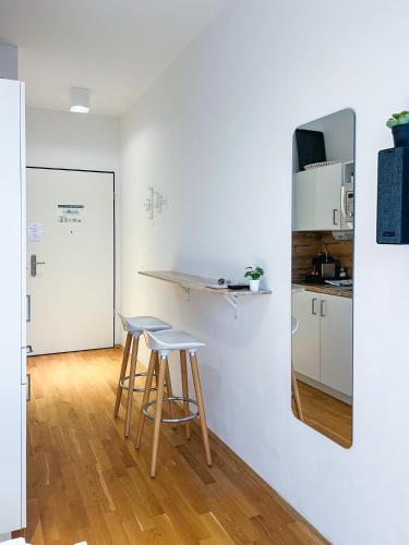 a kitchen with a counter and two stools in a room at My Room Messe Munich Apartment in Munich