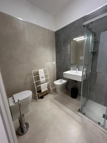 a bathroom with a toilet and a sink and a shower at Fortezza Apartments in Le Castella