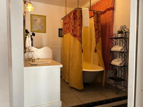 a bathroom with a shower and a sink and a tub at Bisbee Grand Hotel, Saloon, and Music Venue in Bisbee