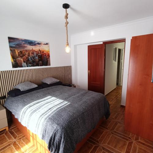 a bedroom with a bed and a painting on the wall at Casa Lolo in Algodonales