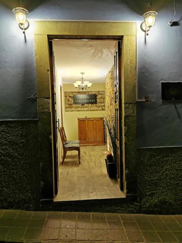 a door leading into a hallway with a chair at H casa pósitos in Guanajuato