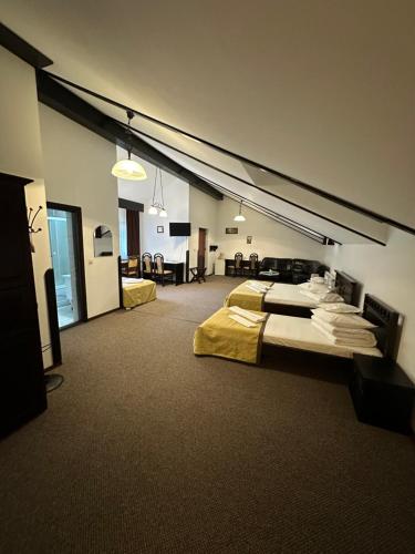 a large room with two beds and a living room at Pensiunea Mugur De Fluier in Vama