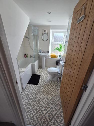 a bathroom with a toilet and a tub and a sink at Cottage in Sandwith in St Bees