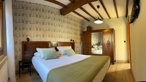 a bedroom with a large bed with white sheets and blue pillows at El Sueño de Celia 1 in Doña Juandi