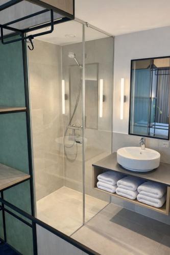 a bathroom with a glass shower and a sink at IBIS STYLES MUENCHEN AIRPORT in Munich
