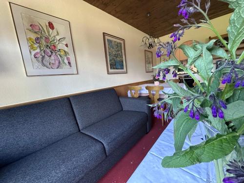 a living room with a couch and some flowers at Chalet Cristall Superior Appartement 10 in Leutasch