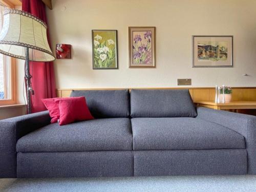 a blue couch with a pink pillow in a living room at Chalet Cristall Superior Appartement 9 in Leutasch