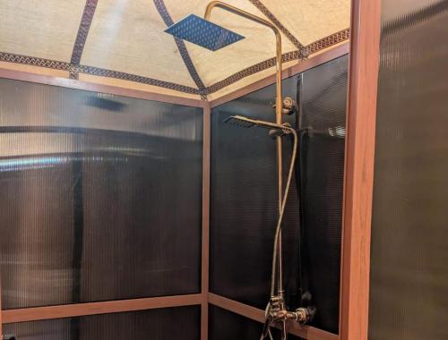 a shower in a bathroom with a ceiling at Achabou Desert Camp in Merzouga
