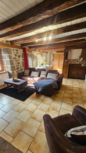 a large living room with couches and a table at Belle résidence auvergnate Vue panoramique sur la nature in Saint-Julien-de-Jordanne