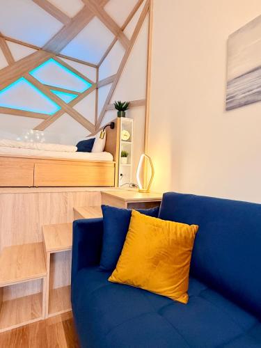 a blue couch in a room with a bed at LelleBay in Balatonlelle