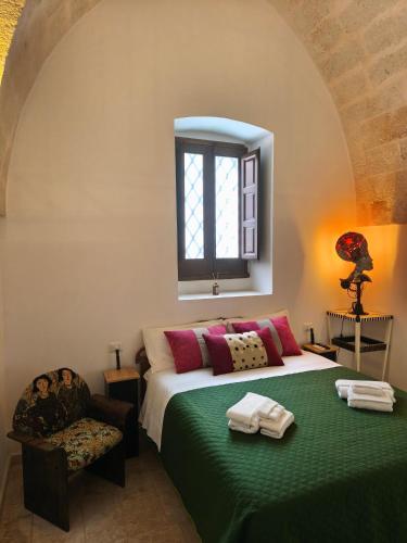 a bedroom with a bed and a chair and a window at Chez Liart 1 in Fasano