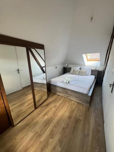 a bedroom with a bed and a large mirror at appartement de charme in Pont-Sainte-Marie