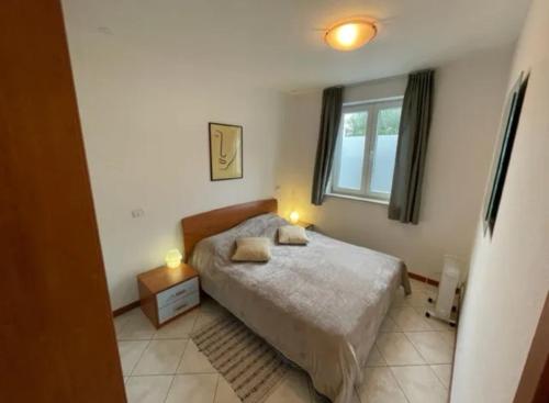 a small bedroom with a bed and a window at Volme home in Banjole