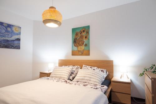 a bedroom with a bed and two paintings on the wall at Rotunda 309 in Dunajská Streda