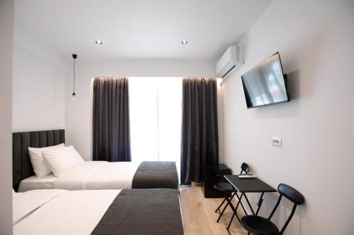 a hotel room with a bed and a tv at Silver Stone Studio Apartments in Gjirokastër