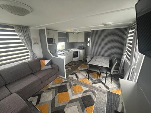a living room with a couch and a table at Belvedere Sleeps 4-6 in Skegness