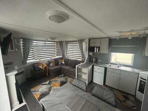 a small living room with a couch and a kitchen at Belvedere Sleeps 4-6 in Skegness