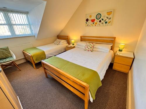a attic bedroom with two beds and a chair at The Shelbourne in Southport