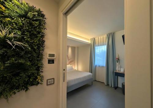 a bedroom with a bed and a plant on the wall at Etna Stone Rooms in Zafferana Etnea