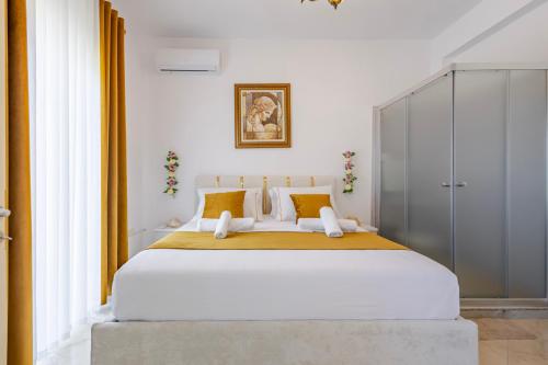 a bedroom with a large white bed with yellow pillows at Vila Dy Bukurite Durres in Draç