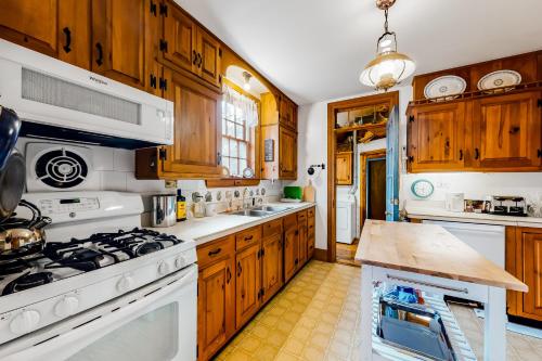 a kitchen with white appliances and wooden cabinets at 1 Mi to Beach! Family-Friendly Nantucket Retreat in Nantucket