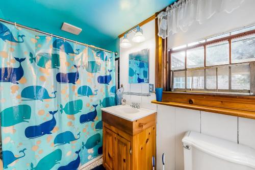 a bathroom with a sink and a shower curtain at 1 Mi to Beach! Family-Friendly Nantucket Retreat in Nantucket
